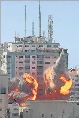  ?? REUTERS ?? An explosion is seen near a tower housing AP, Al Jazeera offices (centre) during Israeli missile strikes in Gaza city.