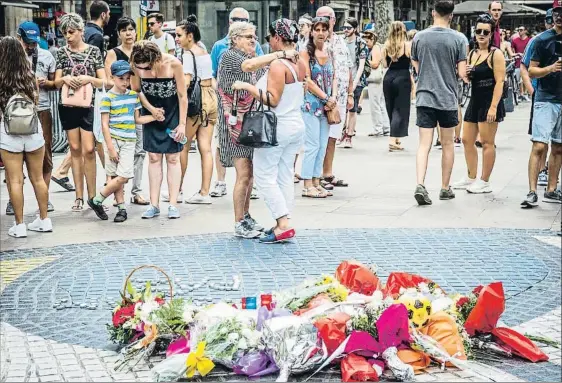  ?? LLIBERT TEIXIDÓ ?? Homenaje espontáneo Ciudadanos y visitantes de Barcelona comenzaron ayer a dejar flores y recuerdos en el mosaico de Miró, en el centro de la Rambla