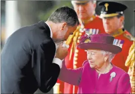  ?? Matt Dunham ?? The Associated Press Spain’s King Felipe kisses the hand of Britain’s Queen Elizabeth II as she greets him during the ceremonial welcome on horse guards parade Wednesday in London. The king and queen of Spain are on a three-day state visit to the...