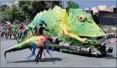  ?? PICTURE: TIMOTHY BERNARD ?? LIZARD MAN: Giant figurines ride the streets of Joburg during the celebratio­ns.