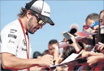  ??  ?? ACLAMADO. Alonso firma muchos autógrafos en Hungría, el escenario de su primera victoria.