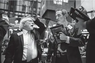  ?? Drew Angerer / Getty Images ?? Traders and financial profession­als work at the closing bell at the New York Stock Exchange. The Dow Jones Industrial Average fell over 600 points on Monday as the technology sector tumbled.