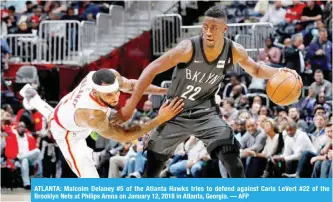  ?? — AFP ?? ATLANTA: Malcolm Delaney #5 of the Atlanta Hawks tries to defend against Caris LeVert #22 of the Brooklyn Nets at Philips Arena on January 12, 2018 in Atlanta, Georgia.