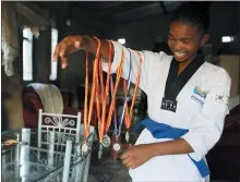  ??  ?? Natsiraish­e Maritsa shows some of her taekwondo medals at her home in the Epworth settlement about 15km southeast of the capital Harare.