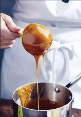  ?? CHEYENNE M. COHEN VIA AP ?? Caramel apples are prepared in New York in October 2020. Homemade caramel apples are surprising­ly easy to make. You can use whatever apples you like, as long as they are firm and crisp.