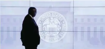  ?? — Reuters ?? A man walks past Federal Reserve logo in Washington.