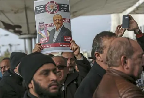  ?? Emrah Gurel/Associated Press ?? A man holds a poster last week showing images of Saudi Crown Prince Mohammed bin Salman and journalist Jamal Khashoggi, describing the prince as “assassin” and Mr. Khashoggi as “martyr” in Turkish and Arabic, during funeral prayers in absentia for the Saudi columnist, who was killed last month.