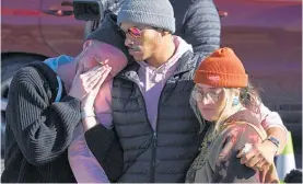  ?? Photo / AP ?? Friends and relatives are among those paying tribute to the victims near Club Q in Colorado Springs.