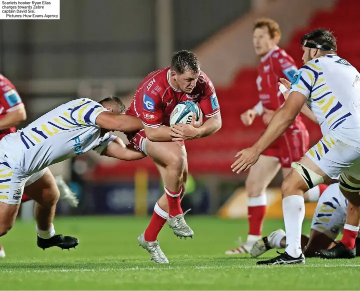  ?? ?? Scarlets hooker Ryan Elias charges towards Zebre captain David Sisi.
Pictures: Huw Evans Agency