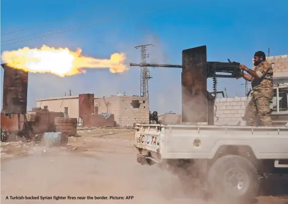  ??  ?? A Turkish-backed Syrian fighter fires near the border. Picture: AFP