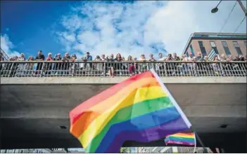  ??  ?? Purposeful pride: Marchers carry messages of defiance against the deportatio­n of queer refugees (above left) during a parade, watched by onlookers (above right). Swedes (left) walk in solidarity for refugees. And a marcher (below) celebrates her...