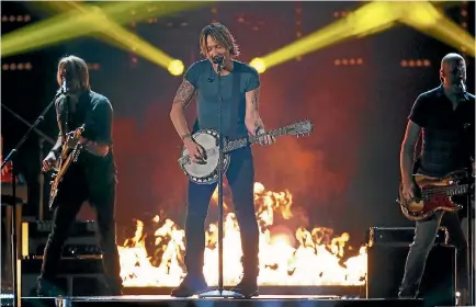 ??  ?? Keith Urban says he enjoys using his ‘‘ganjo’’, a six-string hybrid of banjo and guitar, which he has played on every record he has made.