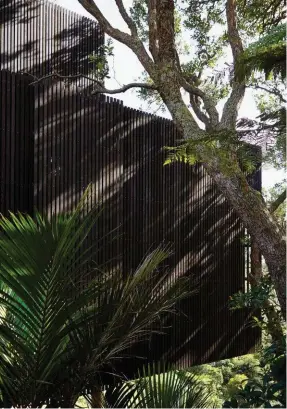  ??  ?? Left Architect Lance Herbst likens the timber rain screen – which denotes the private section of the home – to a veil. Right Custom-brass panelling is a striking feature of the kitchen.