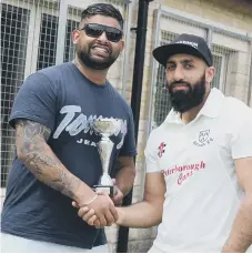  ??  ?? Kasim Ikhlaq (right) receiving a bowling trophy from a match sponsor