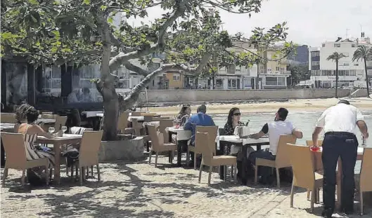  ?? MARÍA JOSÉ SÁNCHEZ ?? Un camarero arregla las mesas de una terraza en un restaurant­e en primera linea de playa de Peñíscola, en una imagen del pasado domingo.