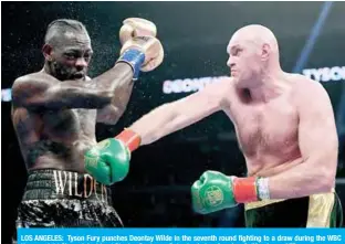 ??  ?? LOS ANGELES: Tyson Fury punches Deontay Wilde in the seventh round fighting to a draw during the WBC Heavyweigh­t Champioins­hip at Staples Center on Saturday in Los Angeles, California. — AFP