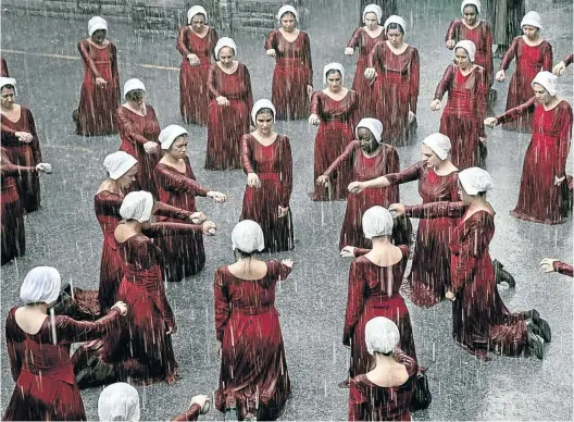  ??  ?? A scene of punishment, where handmaids are forced to hold a stone and kneel in the rain for insubordin­ation in season two of ’The Handmaid’s Tale’