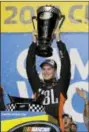  ?? TERRY RENNA - AP ?? Christophe­r Bell celebrates with his trophy in Victory Lane after winning the NASCAR Truck Series auto racing season championsh­ip Friday.