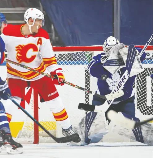  ?? CLAUS ANDERSEN / GETTY IMAGES ?? Matthew Tkachuk of the Calgary Flames tips the Flames’ second goal past Michael Hutchinson of the Maple Leafs on
Monday at Scotiabank Arena. The Leafs were unable to generate any scoring of their own and lost 3-0.