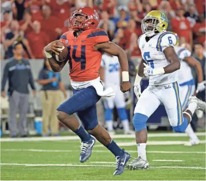  ?? CASEY SAPIO/USA TODAY SPORTS ?? Arizona quarterbac­k Khalil Tate (14) runs the ball under pressure from UCLA defensive back Adarius Pickett during the second half at Arizona Stadium on Oct. 14 in Tucson.