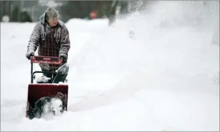  ?? BEN GARVER — THE BERKSHIRE EAGLE VIA AP ?? John Ott clears snow on Madison Avenue in Pittsfield, Mass., Sunday. A major winter storm that has brought some of the coldest temperatur­es of the season covered a large swath of the U.S. in snow as it wreaked havoc on air travel and caused slick road conditions throughout New England.