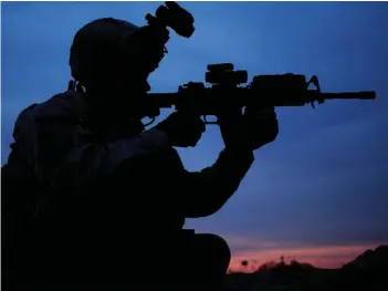  ??  ?? A US Army soldier checks through his rifle scope for any suspicious activity at an observatio­n point in Iraq