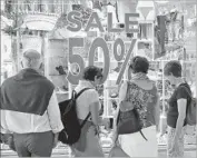  ?? Wilfredo Lee Associated Press ?? WINDOW SHOPPERS browse in Miami Beach. Sales fell 1% in May at department stores, which have struggled with competitio­n from online retailers.