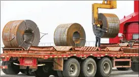  ?? CHINATOPIX ?? A worker positions a roll of steel plate at a dockyard in China’s Jiangsu province. China asked its trading partners to reject “trade and investment protection­ism.”