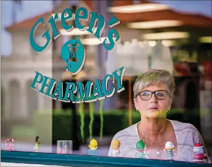  ?? PHOTOS BY STAFF PHOTOGRAPH­ER RICHARD GRAULICH ?? Longtime waitress Carrie Rodriguez stands in the window of Green’s Pharmacy in Palm Beach recently. Rodriguez has terminal cancer and had to quit her job in January.