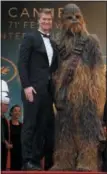  ?? PHOTO BY JOEL C RYAN — INVISION — AP ?? Actor Joonas Suotamo, left, and a person dressed as the character Chewbacca pose for photograph­ers upon arrival at the premiere of the film ‘Solo: A Star Wars Story’.