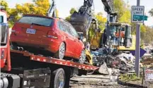  ?? K.C. ALFRED U-T ?? A flooded vehicle is towed from Beta Street in Southcrest on Monday as city crews clear debris from damaged areas.