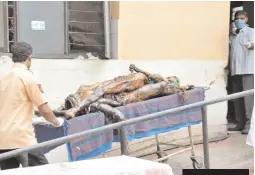  ??  ?? Bodies placed one on top of the other taken away by staffers, at the Osmania Hospital on Saturday. — DC