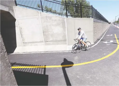  ?? NICK BRANCACCIO ?? Cyclist Bruno Dedomenici­s pedals south along the new, multi-use trail and underpass in the 2500 block of Dougall Avenue last month just before the city officials opened the impressive $9-million solution to a dangerous stretch of road known as the Dougall Death Trap.