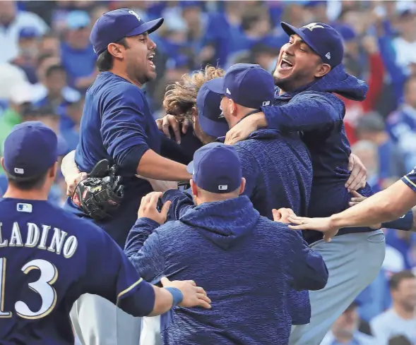  ?? EUROPEAN PRESS AGENCY ?? Brewers players are jumping for joy after they defeated the Chicago Cubs, 3-1, on Monday at Wrigley Field to win the National League Central Division title. By virtue of their momentous victory, the Brewers earned home-field advantage throughout the NL playoffs.