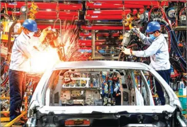  ?? HOANG DINH NAM/AFP ?? Vietnamese employees welding in the body shop at the Ford automotive plant in the northern province of Hai Duong.