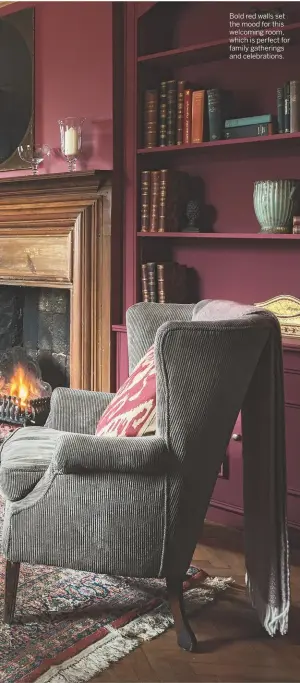  ??  ?? Bold red walls set the mood for this welcoming room, which is perfect for family gatherings and celebratio­ns.