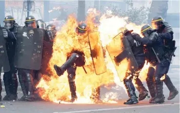  ?? — AFP ?? French CRS anti-riot police officers are engulfed in flames as they face protesters during a march for the annual May Day workers’ rally in Paris.