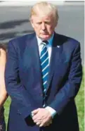  ??  ?? Trump observing a moment of silence at the White House lawn on Monday.
