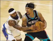  ?? WADE PAYNE — THE ASSOCIATED PRESS ?? Lakers forward Markieff Morris, left, attempts to steal the ball from Grizzlies forward Brandon Clarke during the second half Sunday, in Memphis, Tenn.