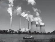  ?? CAROLYN COLE/LOS ANGELES TIMES ?? Fishermen drift by the John E. Amos coal-fired power plant operating on the banks of the Kanawha River near Winfield, W.V.