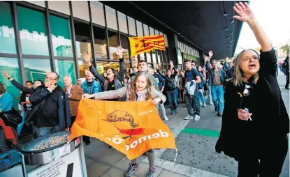  ??  ?? Secesionis­tas apoyan a miembros de la Mesa del Parlamento catalán, antes de viajar en tren a Madrid.