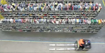  ?? Jens–Ulrich Koch AFP/Getty Images ?? HUNDREDS of books line racks at an Amazon.com distributi­on center in Bad Hersfeld, Germany. Promoting itself as “Earth’s Biggest Bookstore,” Amazon opened for business in July 1995. It went public in 1997.