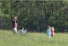  ?? SCOTT KELLER/THE DAILY TIMES VIA AP ?? The Parmley family from South Carolina, from left, Banks, Holly, Madison, 7, and Maci, 6, enjoy a stop in a field in Cades Cove early May 9 as The Great Smoky Mountains National Park reopened for visitors.