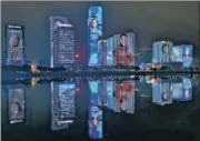  ?? AFP ?? Giant images of health workers from China’s Fujian province are displayed on buildings in Fuzhou city as a mark of tribute.