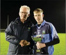  ??  ?? Owen Doyle presents Kian Brady with the Minor Player Pathway League Division 1 trophy after their win over St Nicholas.