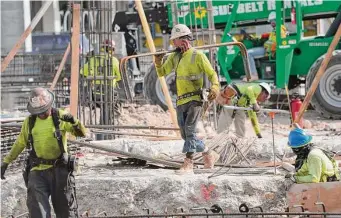  ?? Lynne Sladky/Associated Press ?? People work at a constructi­on site in Miami. Wages and benefits grew 1 percent in the October-December quarter compared with the previous three months.