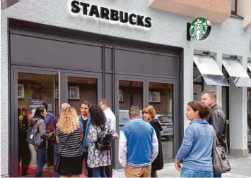 ??  ?? Zwei Handvoll Starbucks Fans warten schon vor der Eröffnung der Filiale am Münsterpla­tz. Der große Ansturm, den es in anderen Städten gab, bleibt in Ulm aber aus.