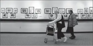  ?? By Bruce A Crippen for USA TODAY ?? Keeping future needs in mind: Shirley Sheff, left, and Etta Gepsman, walk along a hallway at Cedar Village in Masin, Ohio, in January. The artwork on the walls was done by residents.