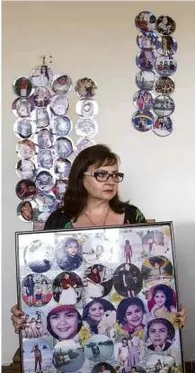  ?? Adolfo Santos Soneria/Folhapress ?? Maria José da Costa, mãe de Raynéia Lima, com fotos da filha em sua casa em Garanhuns (PE)