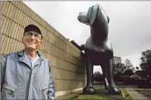  ??  ?? JACKSON stands near his new paint-spurting work, “Bad Dog,” outside the Orange County Museum of Art.